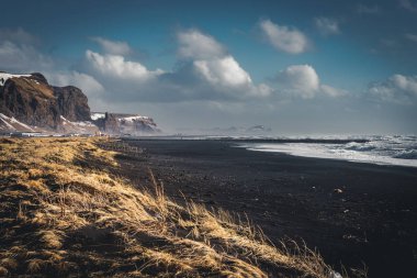 Ünlü siyah kum Beach Reynisfjara İzlanda'daki güneş doğarken. Rüzgarlı sabah. Okyanus dalgaları. Renkli gökyüzü. Sabah günbatımı.