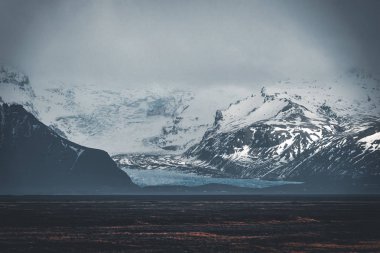 Yol büyük buzul ve İzlanda Vatnajokull buzul hava dron görüntü dağlarda doğru sokak otoyol ve bulutlar ve mavi gökyüzü ile lider. Dramatik kış sahne Vatnajokull Milli Parkı