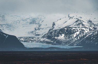 Yol büyük buzul ve İzlanda Vatnajokull buzul hava dron görüntü dağlarda doğru sokak otoyol ve bulutlar ve mavi gökyüzü ile lider. Dramatik kış sahne Vatnajokull Milli Parkı