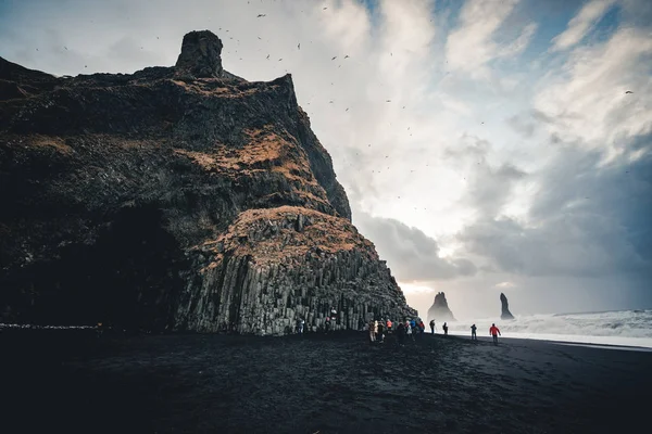 La plage de sable noir de Reynisfjara et le mont Reynisfjall, Islande. Bonjour le vent. Les vagues de l'océan. Ciel coloré. Coucher de soleil du matin . — Photo