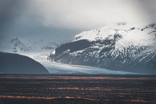 Strada che conduce verso enormi ghiacciai e montagne in Islanda Vatnajokull immagine drone aereo ghiacciaio con strada autostrada e nuvole e cielo blu. Drammatica scena invernale del Parco Nazionale Vatnajokull — Foto Stock