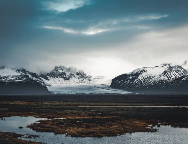 Straße, die in Richtung riesiger Gletscher und Berge in Island Vatnajokull Gletscher Luftbild Drohne mit Straße Autobahn und Wolken und blauem Himmel führt. Dramatische Winterszene im Vatnajokull-Nationalpark — Stockfoto