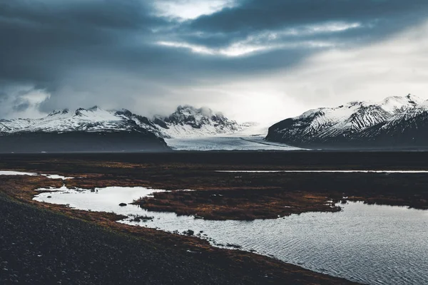 Estrada que leva à enorme geleira e montanhas na Islândia Vatnajokull glaciar drone aéreo imagem com estrada de rua e nuvens e céu azul. Cena de inverno dramática do Parque Nacional Vatnajokull — Fotografia de Stock