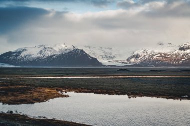 Yol büyük buzul ve İzlanda Vatnajokull buzul hava dron görüntü dağlarda doğru sokak otoyol ve bulutlar ve mavi gökyüzü ile lider. Dramatik kış sahne Vatnajokull Milli Parkı