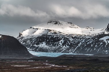 Yol büyük buzul ve İzlanda Vatnajokull buzul hava dron görüntü dağlarda doğru sokak otoyol ve bulutlar ve mavi gökyüzü ile lider. Dramatik kış sahne Vatnajokull Milli Parkı