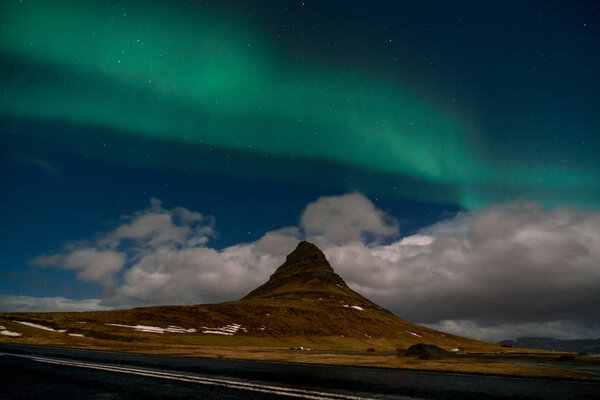 Northern lights aurora borealis appear over Mount Kirkjufell in Iceland.