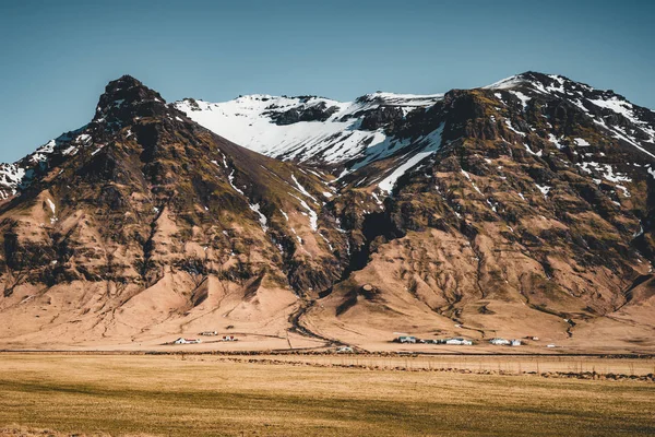 Islande scène typique d'hiver de montagne avec de l'herbe au premier plan et montagne massive en arrière-plan . — Photo
