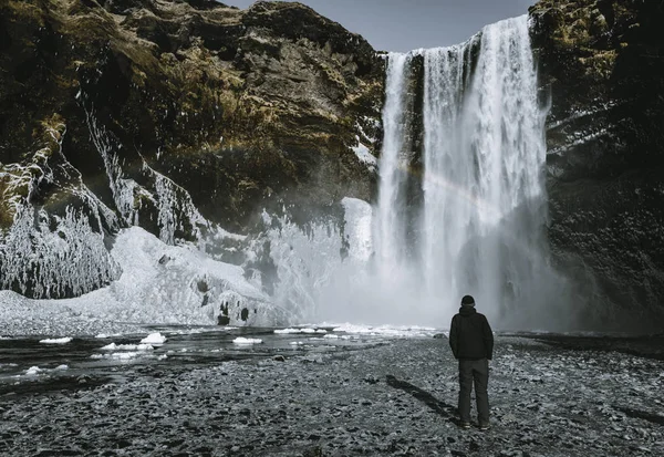 Egy személy admirnig a szépség, a szivárvány Skogafoss vízesés található Izland. — Stock Fotó