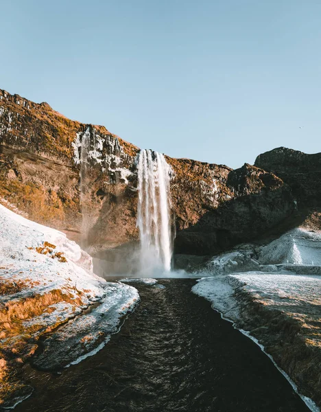 Csodálatos táj, a Seljalandsfoss vízesés Izlandon egy tiszta nap, kék ég és a hó. — Stock Fotó