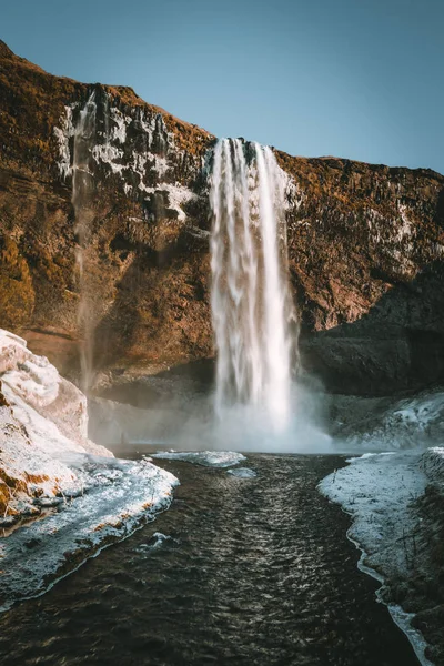 Wunderschöne Landschaft vom Wasserfall Seljalandsfoss in Island an einem klaren Tag mit blauem Himmel und Schnee. — Stockfoto