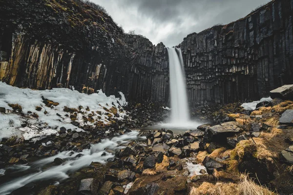 Pohled na dramatické ráno slavný vodopád Svartifoss černá. Barevné letní svítání v Skaftafell, Vatnajokull národní Park, Island, Evropa. Umělecký styl příspěvku zpracovaná fotografie. — Stock fotografie