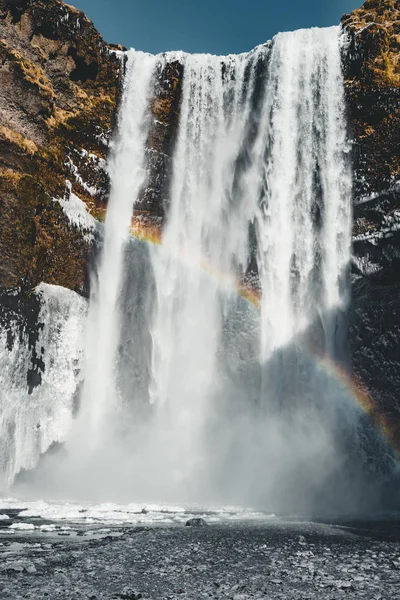 Cachoeira Skogafoss na Islândia com arco-íris em um dia ensolarado com céu azul . — Fotografia de Stock