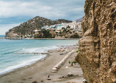 Crete, Yunanistan. Uçurumdan köyü deniz gemiler, tekneler ve deniz feneri ile görüntüleyin. Bay cliff beach ve Mimarlık - tatil tatil köyü ile açık okyanus su ile gelen görüntüleyin. Rethymno