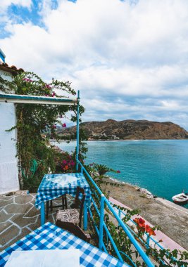 Yunanistan Crete. Restoran deniz görünümü ada su nefes kesen, şaşırtıcı ve inanılmaz manzaralı sahil hizmet tablo ile. Mavi kareli masa örtüsü ile geleneksel Yunan tavernası.