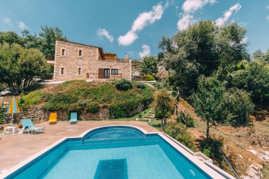 Mesonisia, Rethymno, Girit - Ağustos 2018: Görünümü ile bulanıklık gökyüzü güneşli bir yüzme havuzlu villa Krios doğru. Kriyus Villa Rethymno, Crete Mesonisia köyünde bulunan bir tesistir.