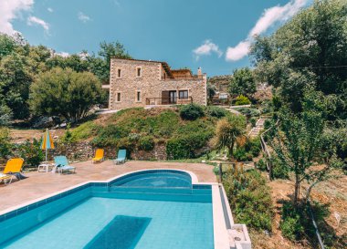 Mesonisia, Rethymno, Girit - Ağustos 2018: Görünümü ile bulanıklık gökyüzü güneşli bir yüzme havuzlu villa Krios doğru. Kriyus Villa Rethymno, Crete Mesonisia köyünde bulunan bir tesistir.