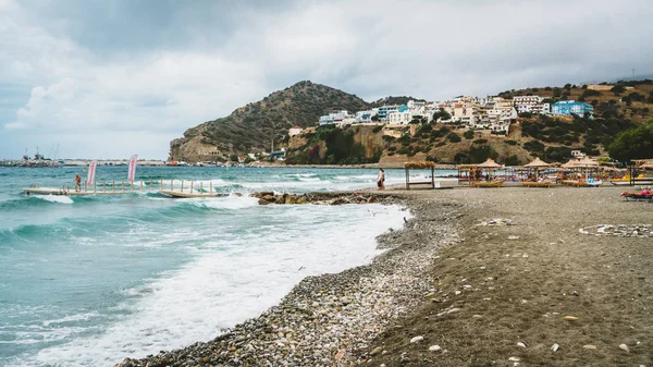 Guarda-chuva palha em uma praia de areia na Grécia. Cadeiras de praia com guarda-chuvas em uma bela praia na ilha de Creta . — Fotografia de Stock