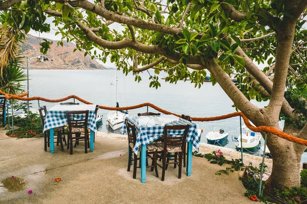 Greece Crete. Restaurant with served table in seafront of sea view island with breathtaking, amazing and unbelievable view on the water. Traditional greek tavern with blue checkered table cloth. Photo