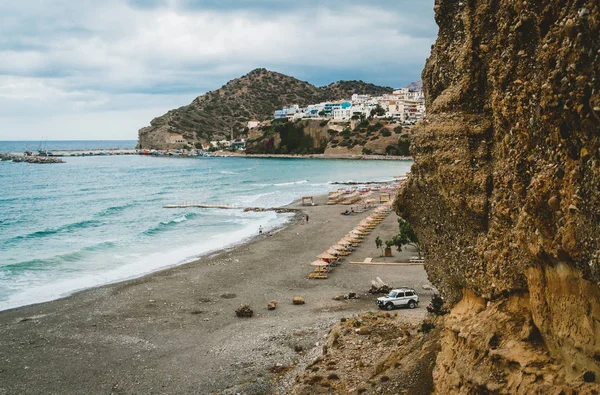 Creta, Grécia. Vista de penhascos para aldeia com embarcações marinhas, barcos e farol. Vista de penhasco na Baía com praia e arquitetura - resort de destino de férias com água do mar clara. Retimno. — Fotografia de Stock