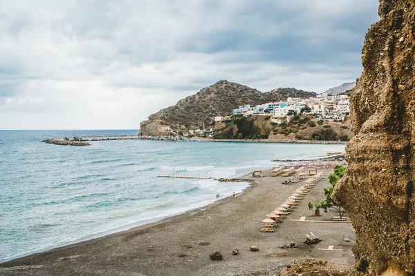 Creta, Grécia. Vista de penhascos para aldeia com embarcações marinhas, barcos e farol. Vista de penhasco na Baía com praia e arquitetura - resort de destino de férias com água do mar clara. Retimno. — Fotografia de Stock