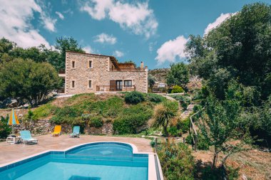 Mesonisia, Rethymno, Girit - Ağustos 2018: Görünümü ile bulanıklık gökyüzü güneşli bir yüzme havuzlu villa Krios doğru. Kriyus Villa Rethymno, Crete Mesonisia köyünde bulunan bir tesistir.