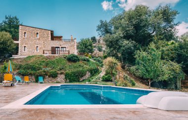 Mesonisia, Rethymno, Girit - Ağustos 2018: Görünümü ile bulanıklık gökyüzü güneşli bir yüzme havuzlu villa Krios doğru. Kriyus Villa Rethymno, Crete Mesonisia köyünde bulunan bir tesistir.