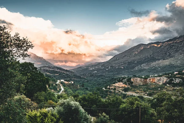 Sunset View on mountains with low hanging clouds orange twilight and green trees. South Crete neat Rethymno, Greece — Stock Photo, Image