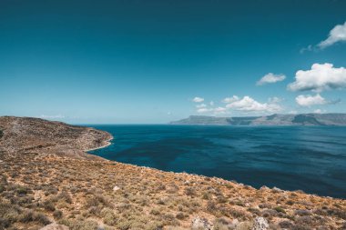 Panoramik kayalar ve gökyüzü ve bulutlar Girit, Yunanistan ile plaj. Kristal berraklığında su ve derin mavi gökyüzü karşı kaya oluşumu yaz döneminde inanılmaz sahne. Yunanistan, Europe