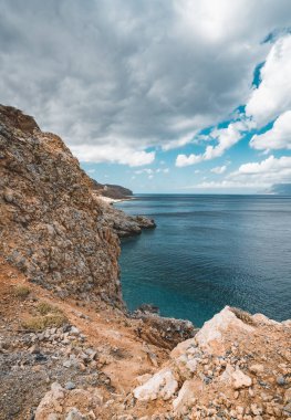 Panoramik kayalar ve gökyüzü ve bulutlar Girit, Yunanistan ile plaj. Kristal berraklığında su ve derin mavi gökyüzü karşı kaya oluşumu yaz döneminde inanılmaz sahne. Yunanistan, Europe