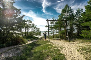 Kumlu plajı ile Litvanya kıyı sahne, dunes marram çim ve mavi gökyüzü ile bir açık yaz gününde kaba deniz kıyı alanında.