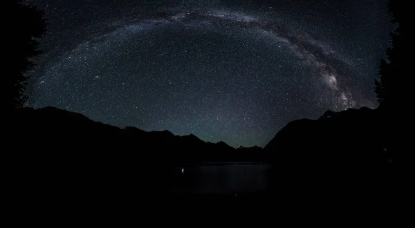 Panorama Vía Láctea galaxia cielo nocturno sobre un pequeño estanque con reflejo. Canadá, Columbia Británica . —  Fotos de Stock