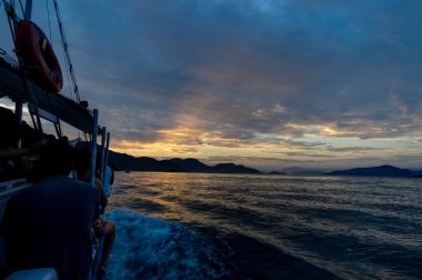 Günbatımı sırasında su okyanusun üzerinde tekne