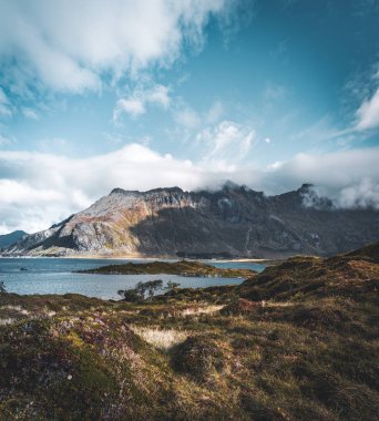 Deniz ve dağlar Lofoten Adaları, Norveç'te üzerinde köprü görünümünü. Hamnoy ridge günbatımında kışın. Manzara mavi su, kar, yol ve cloads ile gökyüzü kayalar. Üstten görünüm