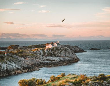 Gündoğumu ve günbatımı pembe gökyüzü ile Henningsvaer feneri. Lofoten Adalar, Norveç bulutlar mavi bir gökyüzü üzerinde birkaç küçük adalar üzerinde bulunan küçük bir balıkçı köyü.