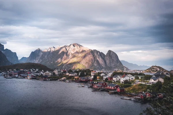 Paisaje del pueblo pesquero Reine con el fiordo de Reine durante el atardecer con bonitas luces en la montaña, cielo azul y nubes. Lofoten, Noruega —  Fotos de Stock