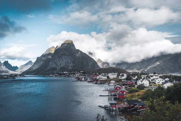 Landskap av fiskebyn Reine med Reine fjorden under solnedgång med fina lampor på berget, blå himmel och moln. Lofoten, Norge — Stockfoto