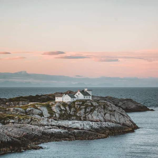 Nascer do sol e pôr do sol no farol Henningsvaer com céu rosa. A pequena aldeia piscatória localizada em várias pequenas ilhas no arquipélago Lofoten, Noruega sobre um céu azul com nuvens . — Fotografia de Stock