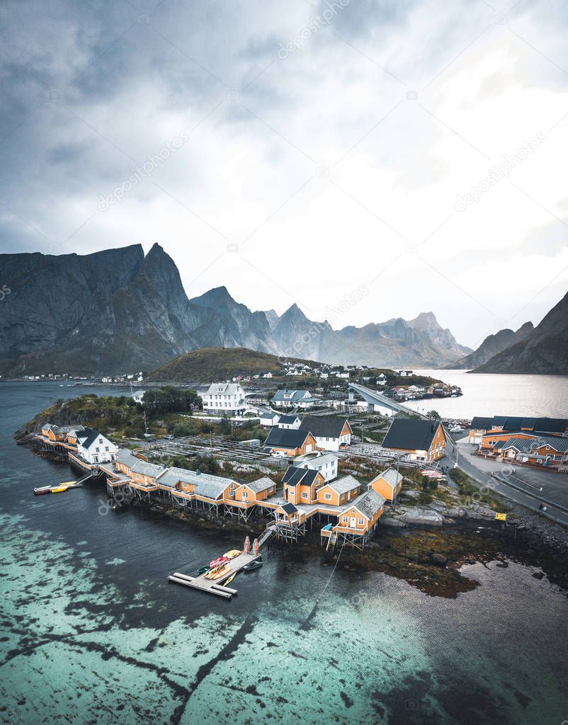 Beautiful view aerial drone of scenic Sakrisoy village Lofoten Islands archipelago scenery with traditional yellow fisherman Rorbuer cabins in the historic village of Sakrisoy at sunrise, Norway