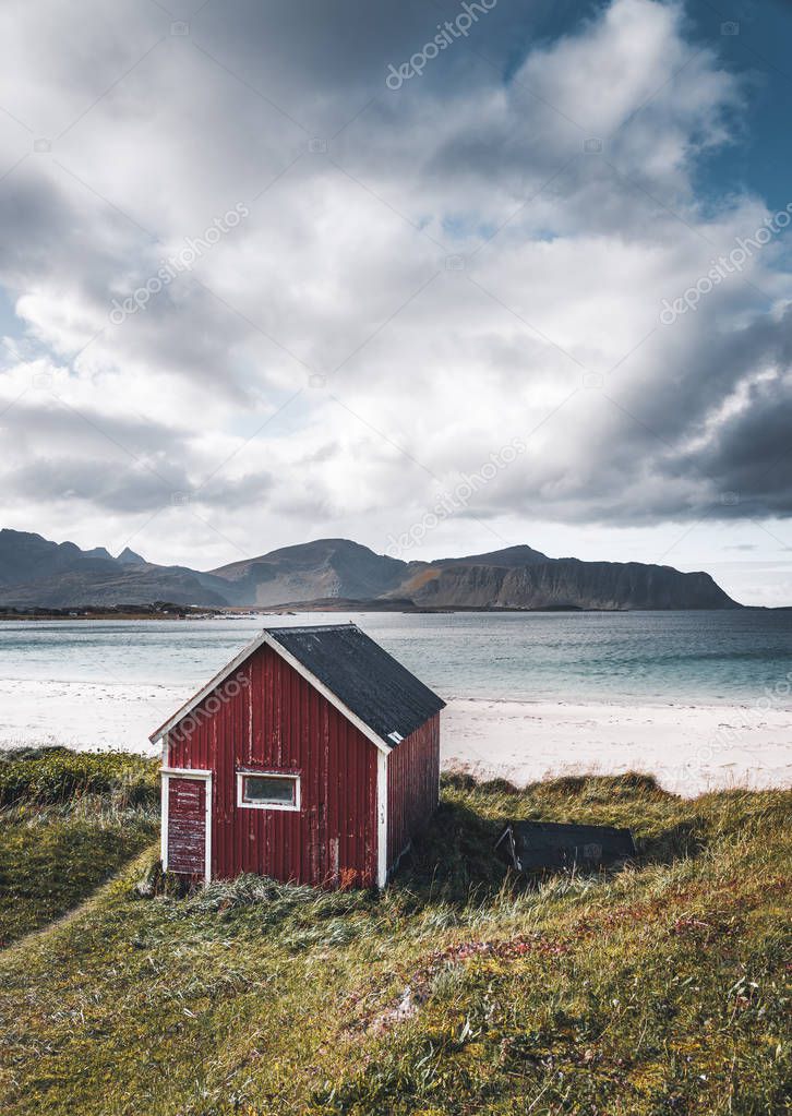 A typical house of the fishermen called rorbu on the beach frames the sea at Ramberg Lofoten Islands, Norway Europe