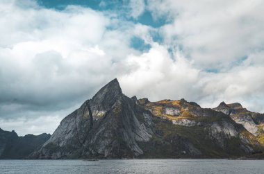 Lofoten Norveç görünümü doğru dağ atantic okyanus ve kayaların ön planda. Mavi gökyüzü ile bulutlu bir günde alınan.