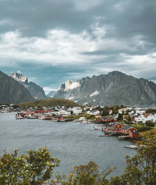 Landschap van vissersdorp Reine met de Reine Fjord tijdens zonsondergang met mooie verlichting op de berg, de blauwe lucht en de wolken. Lofoten, Noorwegen — Stockfoto