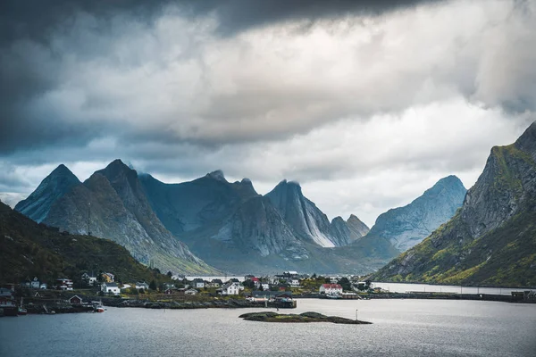 Landskap av fiskebyn Reine med Reine fjorden under solnedgång med fina lampor på berget, blå himmel och moln. Lofoten, Norge — Stockfoto