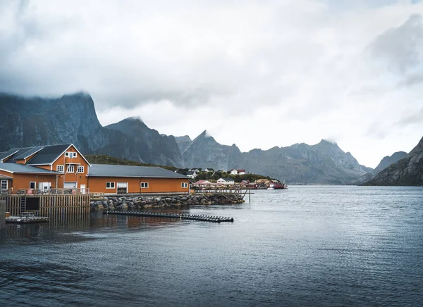 黄色がりは、山を背景に、曇りの日に Sakrisoy の漁村の家します。、ノルウェーのロフォーテン諸島 — ストック写真