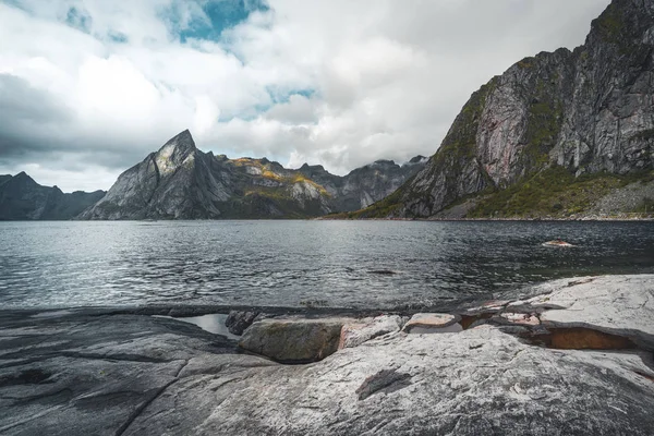 Lofoten Norge utsikt mot berget med atantic havet och klipporna i förgrunden. Tagit en molnig dag med blå himmel. — Stockfoto