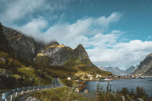 Kurvenreicher Roadtrip in Richtung Reinebringen auf den erhabenen Inseln mit Bergen im Hintergrund. Bewölkter und launischer Himmel mit Atlantik. — Stockfoto