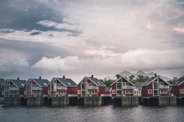 Svolvær, Norwegia - września 2018: Czerwony domów nabrzeża z zachodu słońca w tle. Svolvær jest wieś i turystyczne miasteczko rybackie położone na Austvagoya na Lofotach. — Zdjęcie stockowe