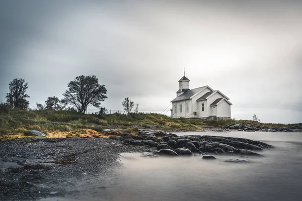 Larga exposición de la iglesia blanca de Gimsoy con rocas y océano atlántico. Foto tomada en la isla de Gimsoy, Lofoten Noruega . — Foto de Stock