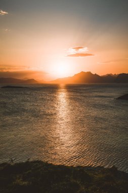 Gündoğumu ve günbatımı, Henningsvaer, Lofoten Adalar, Norveç üzerinde mavi bir gökyüzü bulutlu Dağları içinde belgili tanımlık geçmiş ile birkaç küçük adalar üzerinde bulunan balıkçı köyü.