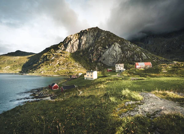 赤いがりとロフォーテン諸島、ノルウェーのレーヌの近く Bjoernsand で伝統的な赤いフィッシン家住宅します。砂浜で雲と夕日の午後. — ストック写真