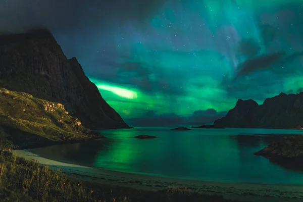 Aurora sobre haukland praia arenosa, Kvalvika e Skagsanden com pedras na Noruega, ilhas Lofoten. Luzes do norte nas ilhas Lofoten, Noruega. Céu estrelado com luzes polares. Paisagem noturna com verde — Fotografia de Stock